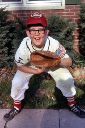 "Santa Baby 1963" now in the early 1970's in Rochester, Indiana. Kodachrome. View full size.
Little LeagueI had forgotten about the art of putting two folds on the bill of a baseball cap. My teammates and I knew we were cool once we folded the bills of our caps.
Alternate WorldsHello,
It's me again, the woman who grew up in Warren, Michigan, wearing the same eyeglasses (two pairs!) as your sister and having the same Christmas reindeer (different color) as your brother.
We had the exact same shrubs planted in the front and back of our house.  They gave my mom a horrible rash whenever she tried to pull weeds near them.
Either everyone in the country was wearing and growing the same things or... Rochester, Indiana and Warren, Michigan are weird alternative worlds.
Looking forward to each new slide to see what else our families shared...my grandpa was the slide fan in our family btw.
Mailbox RollFashion can be strange, many of my buddies back in the late-'70s and early-'80s went for a sharply-arched roll. Of course the rest of us mercilessly called it a 'mailbox roll' and jokingly implied that this was so they could leave their hat on when they were checking to see if the welfare check had arrived....
I rememberMy brother used wear his baseball caps the same way, he even had the same style glasses. Once again the subject is squinting in the sun. 
Braces and dimplesThose are some dynamite dimples! It looks like maybe he would have had braces some time in the 70s.  I'll bet, after those came off, he was pretty popular with the girls, with that charming grin!
(ShorpyBlog, Member Gallery, Kids)